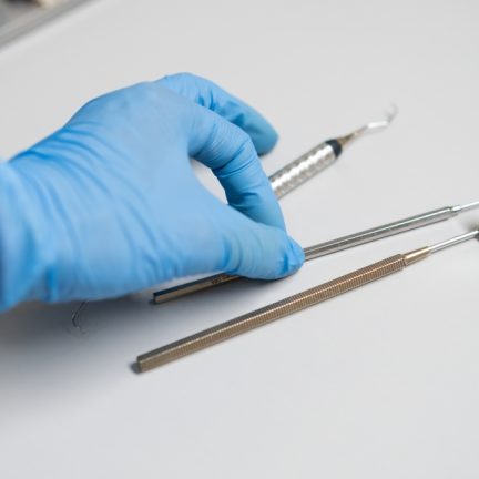 Dentist,In,Rubber,Gloves,Takes,The,Dental,Hook,From,The